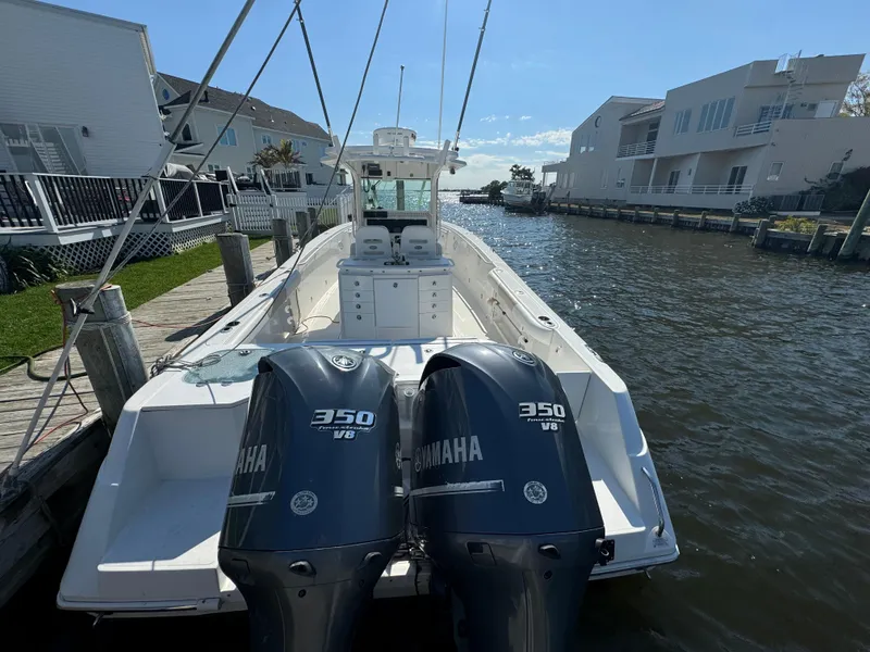 Slide: The Image of 2011 Everglades 325 Center Console boat with twin Yamaha 350 engines docked by waterfront homes. - 4