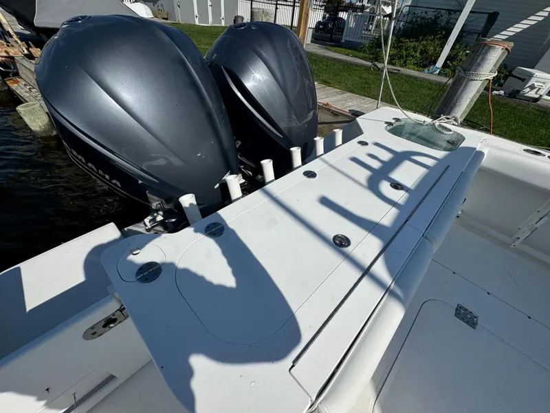Slide: The Image of 2011 Everglades 325 Center Console boat with dual engines docked by the water. - 5