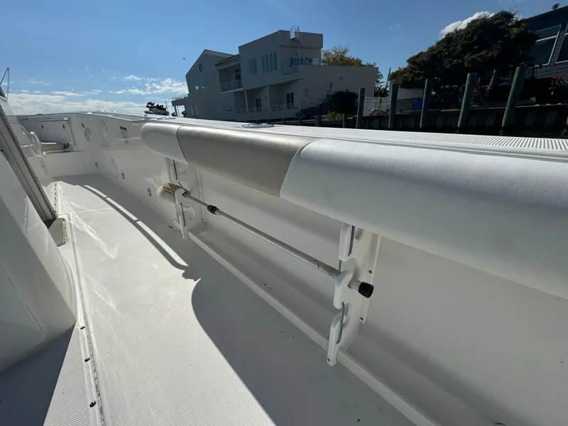 Slide: The Image of 2011 Everglades 325 Center Console boat deck with padded railing, docked near waterfront homes. - 7