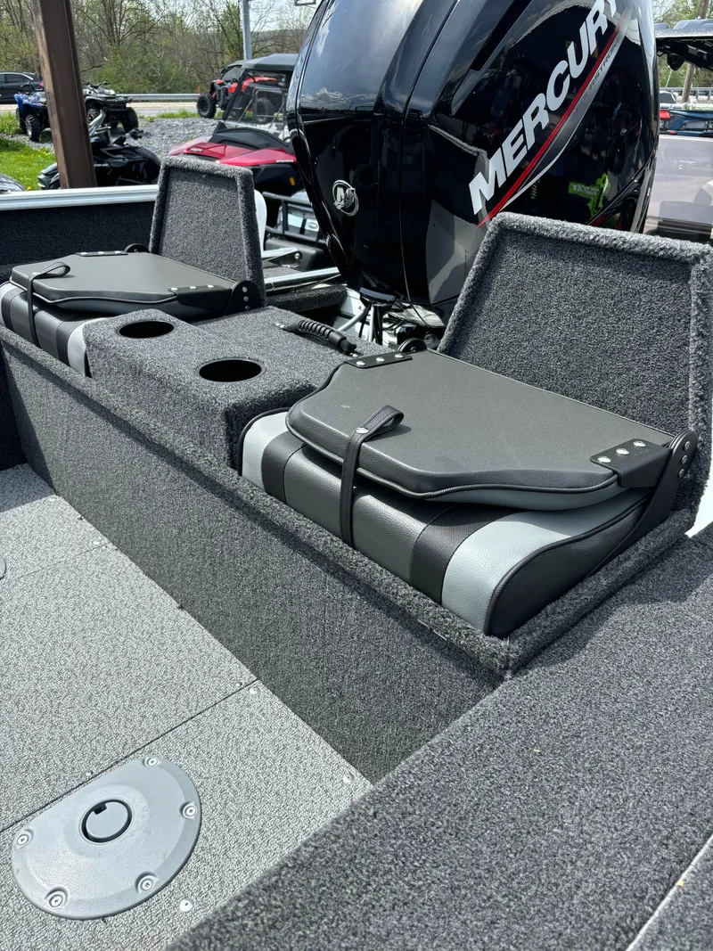Slide: The Image of 2025 Lund 1650 Rebel XL Sport boat interior with Mercury engine, featuring seating and storage. - 7