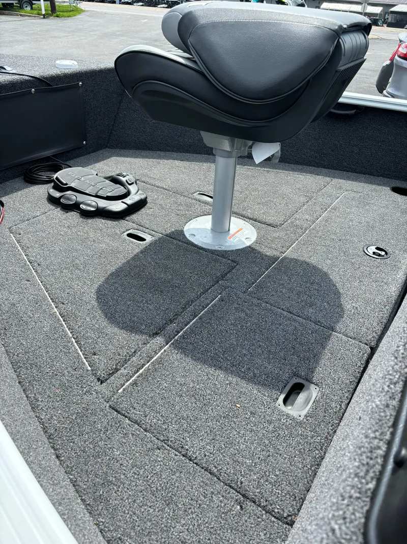 Slide: The Image of 2025 Lund 1650 Rebel XL Sport boat interior with swivel seat and carpeted deck. - 8