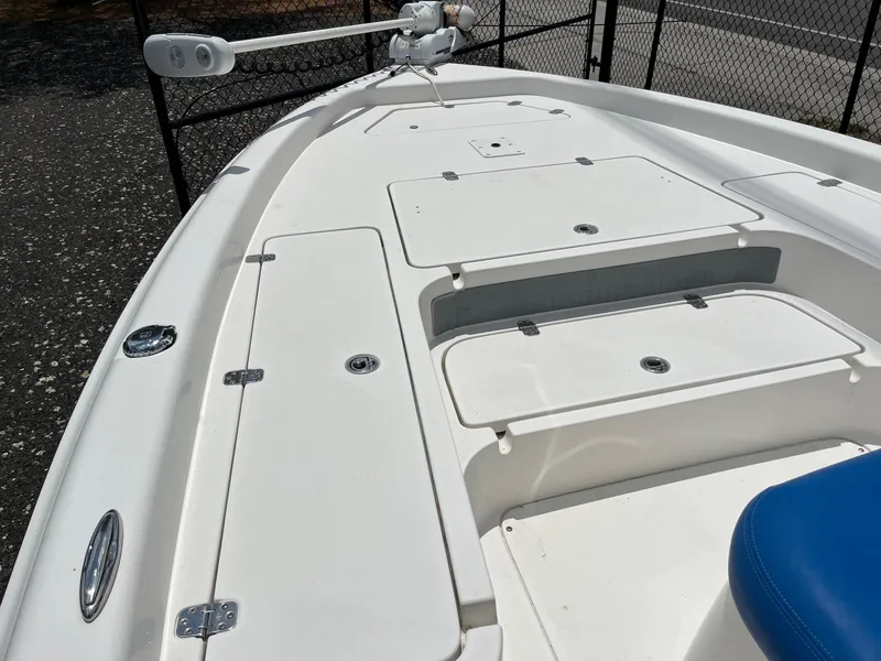 Slide: The Image of 2017 ShearWater 23LTZ boat deck with storage compartments and trolling motor. - 12