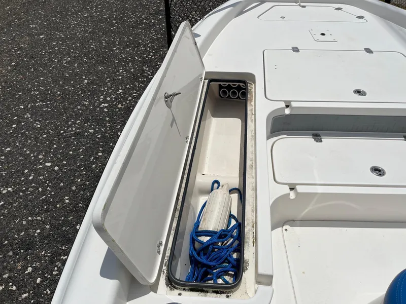 Slide: The Image of Open storage compartment on 2017 ShearWater 23LTZ boat with blue rope inside. - 2