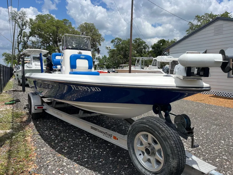 Slide: The Image of 2017 ShearWater 23LTZ boat on trailer, blue and white, parked outdoors. - 3