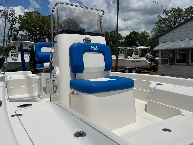 Slide: The Image of 2017 ShearWater 23LTZ boat with blue and white seating, docked outdoors. - 4