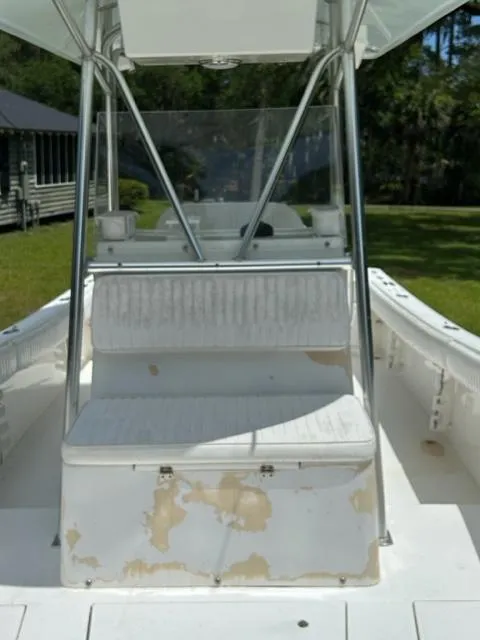 Slide: The Image of 2000 Regulator 23' Center Console boat with worn seating and console, set outdoors. - 13