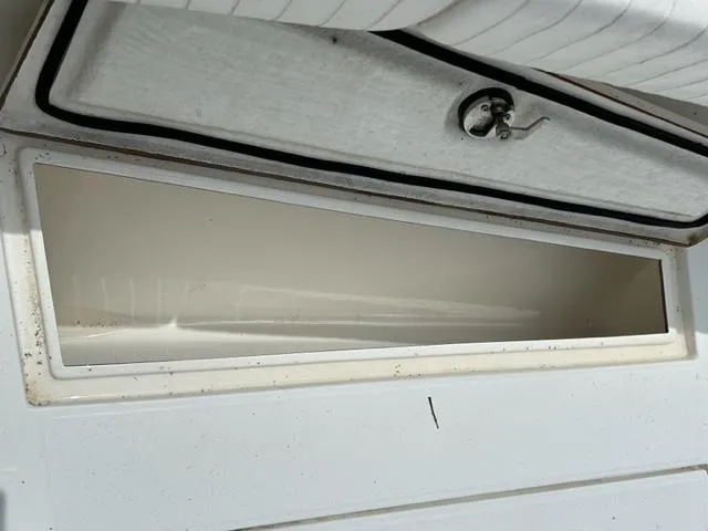 Slide: The Image of Open storage compartment on a 2000 Regulator 23' Center Console boat. - 16