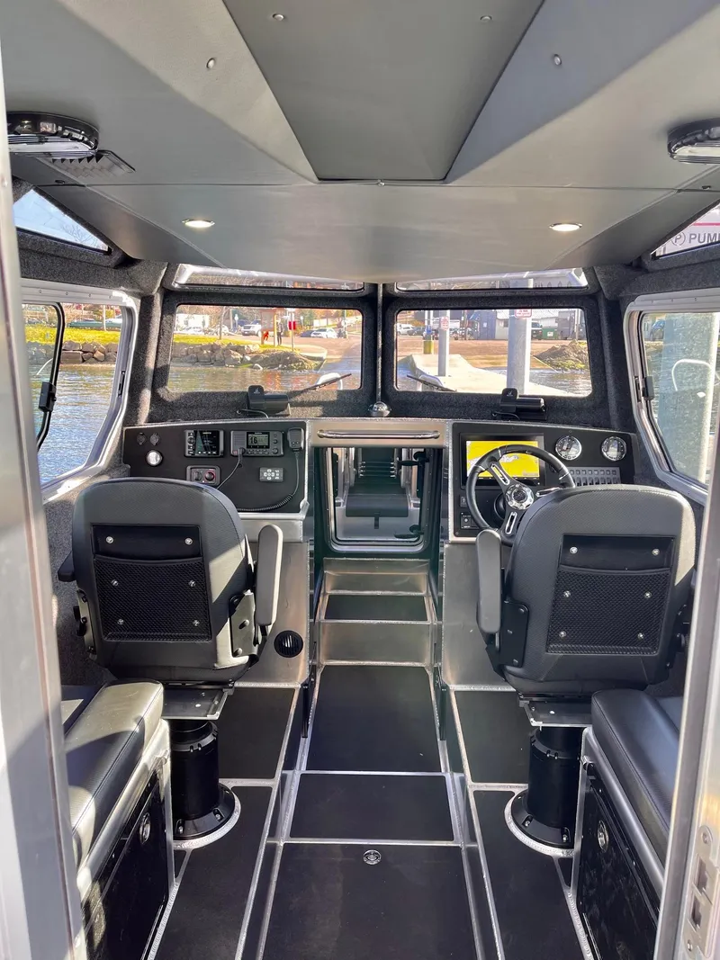 Slide: The Image of Interior of a 2021 Life Proof 25 Full Cabin boat, featuring modern seating and controls. - 17