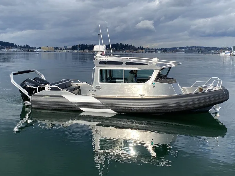 Slide: The Image of 2021 Life Proof 25 Full Cabin boat on calm water under cloudy skies. - 2