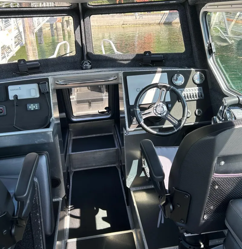 Slide: The Image of 2021 Life Proof 25 Full Cabin boat interior with steering wheel and control panel. - 21