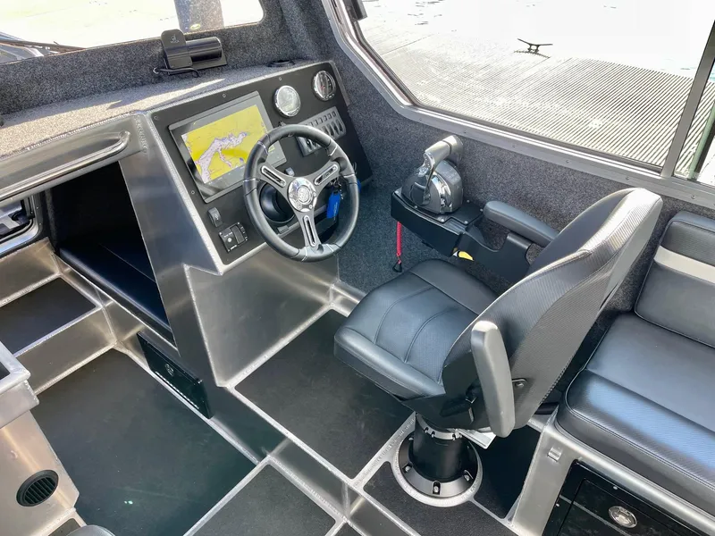 Slide: The Image of 2021 Life Proof 25 Full Cabin boat interior with steering wheel and navigation system. - 22