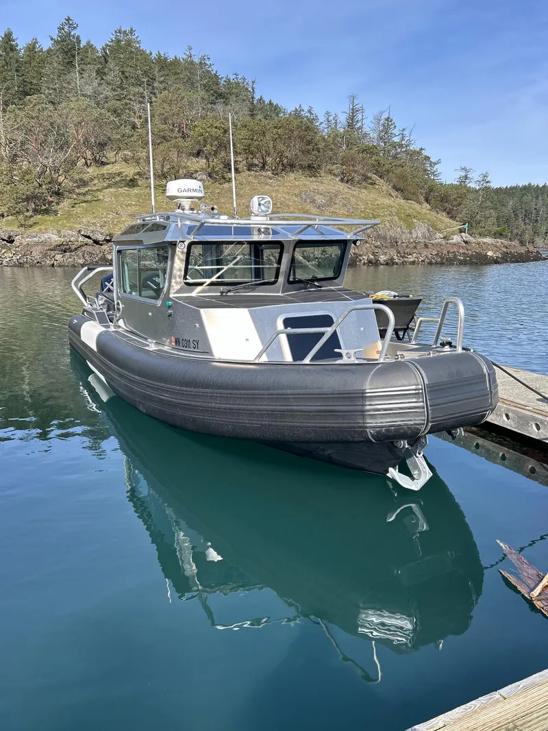 Slide: The Image of 2021 Life Proof 25 Full Cabin boat docked on calm water, surrounded by lush greenery. - 26
