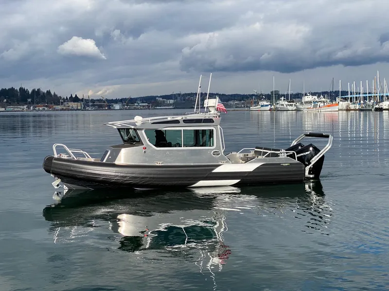 Slide: The Image of 2021 Life Proof 25 Full Cabin boat on calm water, overcast sky, marina in background. - 32