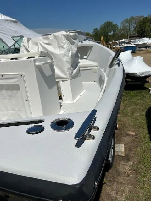 Slide: The Image of 2016 Allied Sportsman boat, white exterior, docked outdoors on a sunny day. - 2