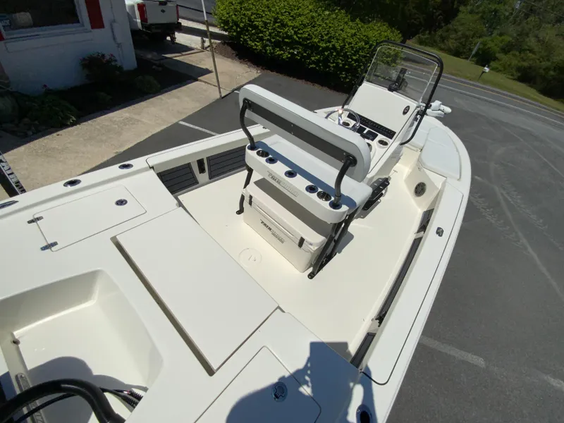 Slide: The Image of 2025 Pathfinder 2200 TRS boat interior with seating and console, parked outdoors. - 11