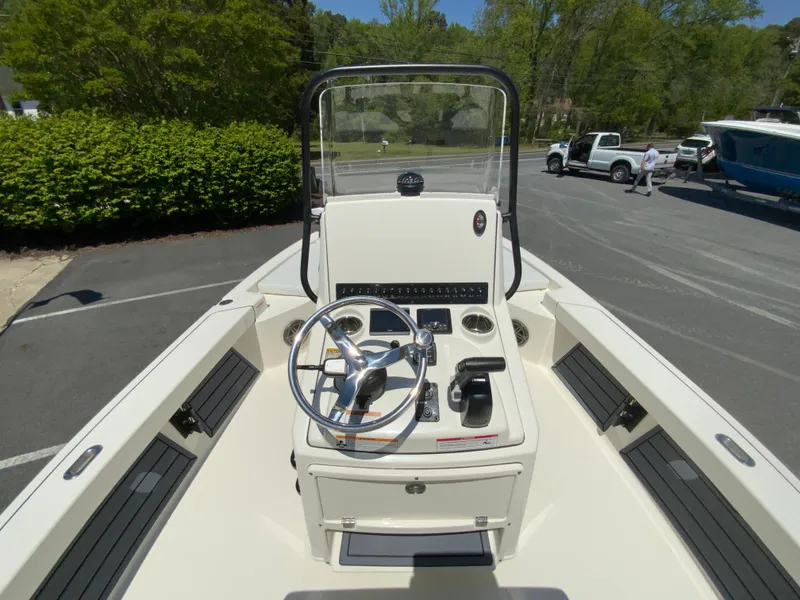 Slide: The Image of 2025 Pathfinder 2200 TRS boat console with steering wheel and controls, parked outdoors. - 12