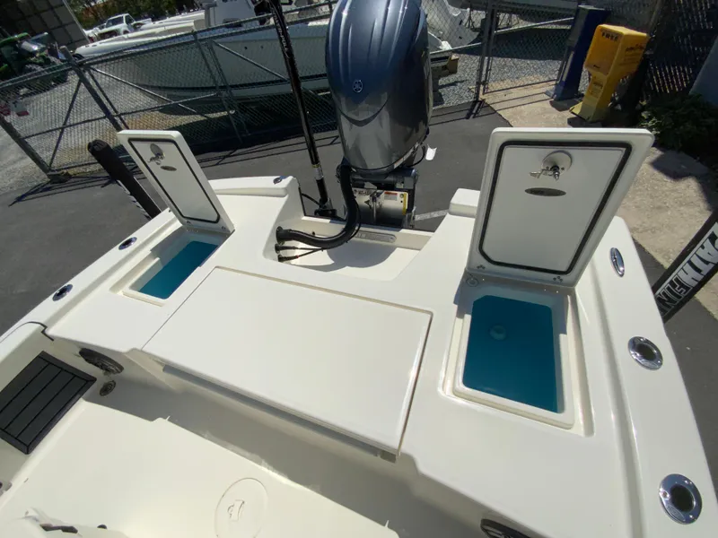 Slide: The Image of 2025 Pathfinder 2200 TRS boat with open storage compartments and outboard motor. - 17