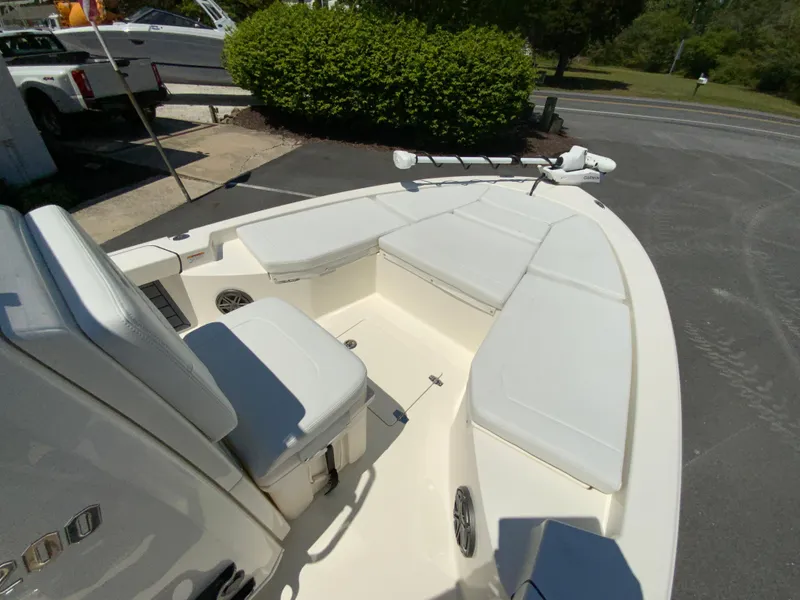 Slide: The Image of 2025 Pathfinder 2200 TRS boat with cushioned seating and trolling motor, parked outdoors. - 18