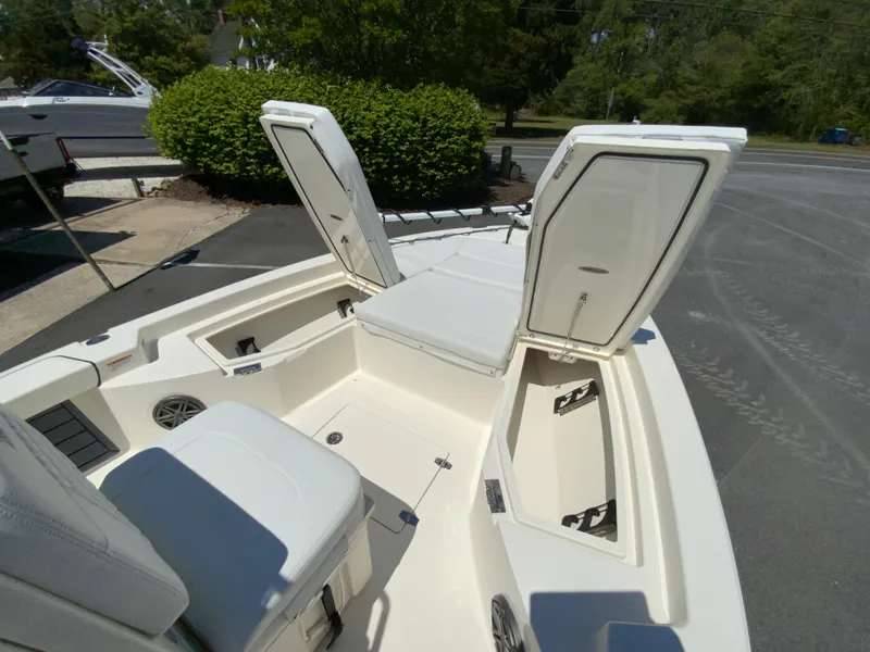 Slide: The Image of 2025 Pathfinder 2200 TRS boat with open storage compartments and seating, displayed outdoors. - 19