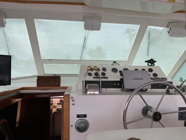 Slide: The Image of 1987 Bertram Motoryacht helm with steering wheel, Garmin navigation, and control panel. - 4