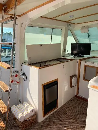 Slide: The Image of 1987 Bertram Motoryacht interior with TV, mini-fridge, and wooden accents. - 6