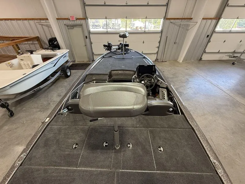 Slide: The Image of 2025 Skeeter ZXR19 boat interior in a garage, showcasing seating and control console. - 21