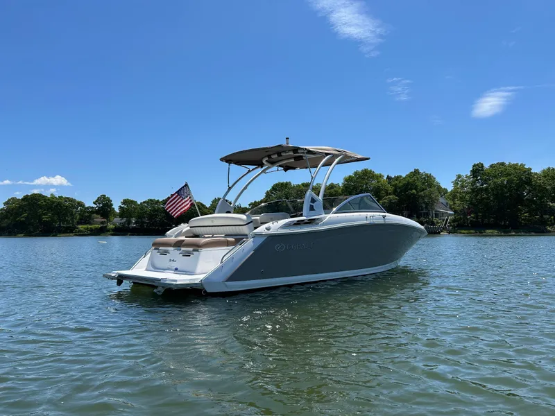 Slide: The Image of 2015 Cobalt 24SD boat on a sunny lake with an American flag. - 1