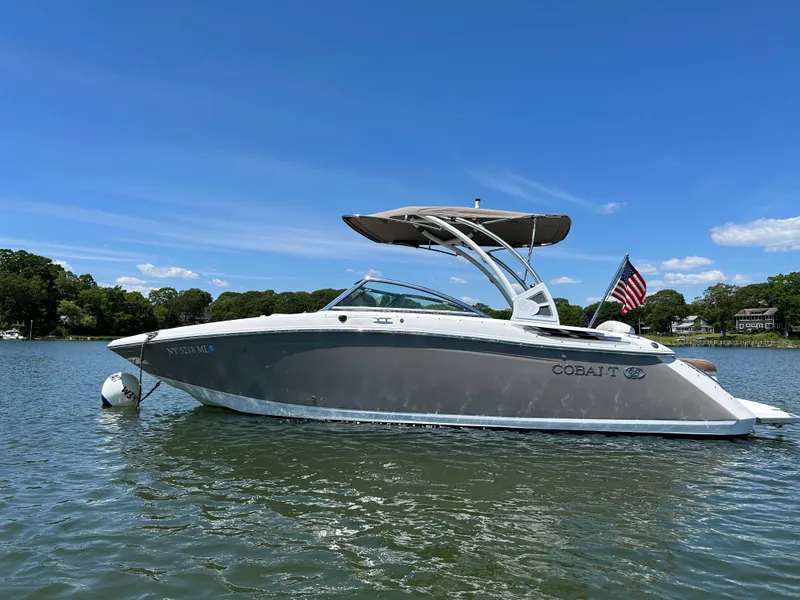Slide: The Image of 2015 Cobalt 24SD boat on a lake with clear blue skies. - 2