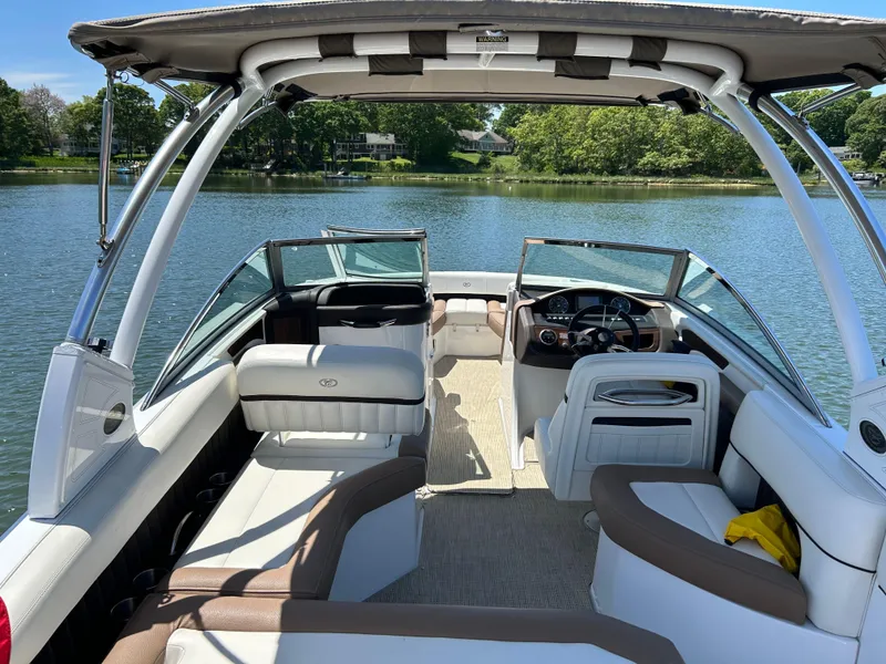 Slide: The Image of 2015 Cobalt 24SD boat interior with seating, steering wheel, and lake view. - 4