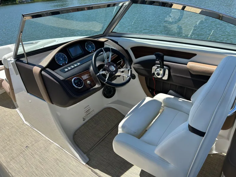 Slide: The Image of 2015 Cobalt 24SD boat cockpit with steering wheel and controls, overlooking water. - 6