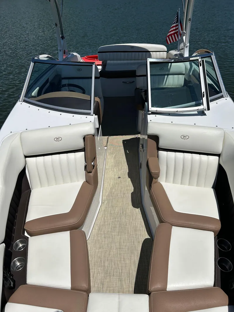 Slide: The Image of 2015 Cobalt 24SD boat interior with white and brown seating, open deck, and American flag. - 8