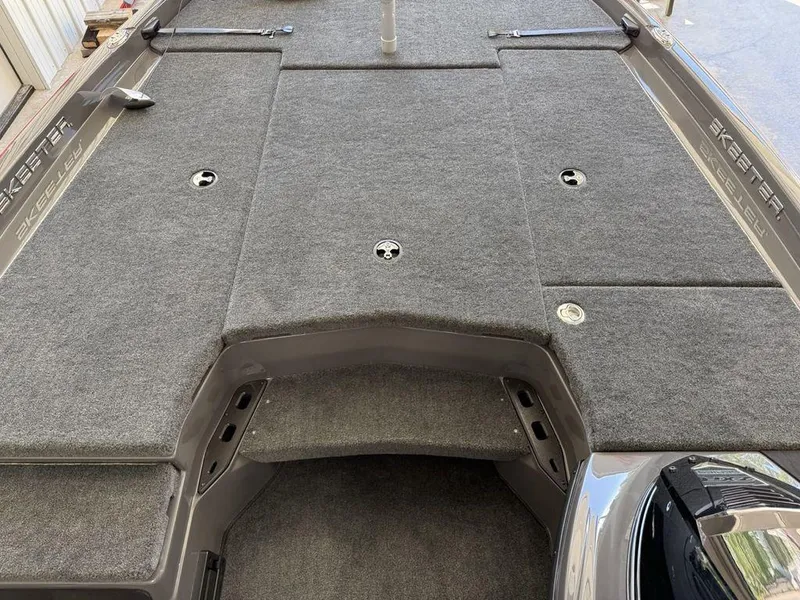 Slide: The Image of 2025 Skeeter ZXR19 boat deck with gray carpet and storage compartments. - 8