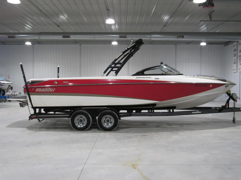 Slide: The Image of 2007 Malibu Sunscape 247 LSV boat in a garage, red and white design. - 0