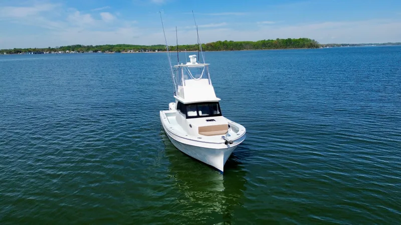 Slide: The Image of 2023 Millennium Marine NuWave 37 boat on calm water, clear sky background. - 1