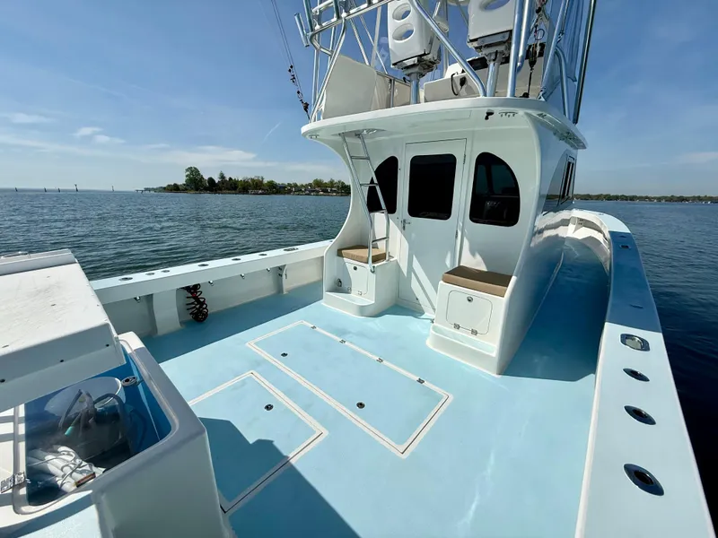 Slide: The Image of 2023 Millennium Marine NuWave 37 boat on calm water, featuring spacious deck and seating. - 10