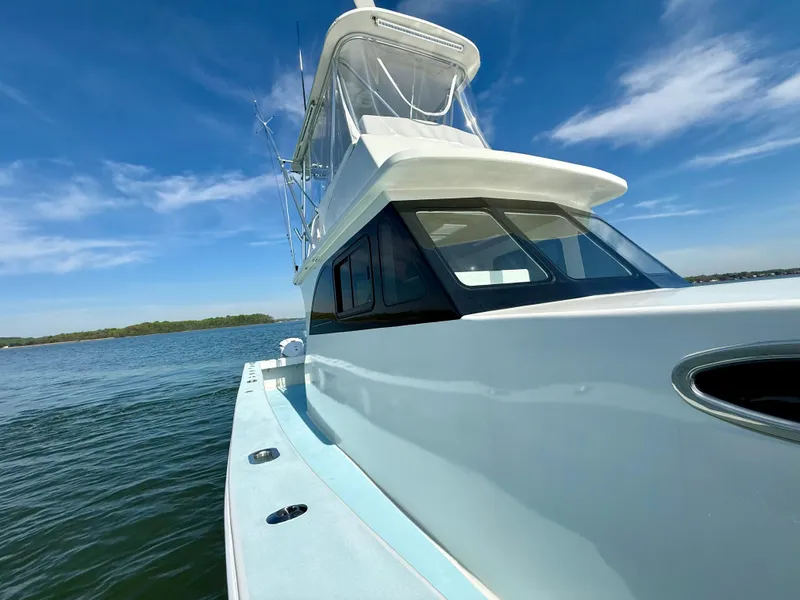 Slide: The Image of 2023 Millennium Marine NuWave 37 boat on calm water under clear blue sky. - 15