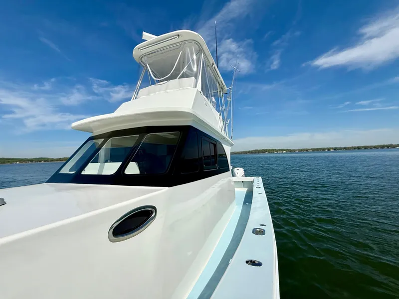 Slide: The Image of 2023 Millennium Marine NuWave 37 boat on calm water under clear blue sky. - 16