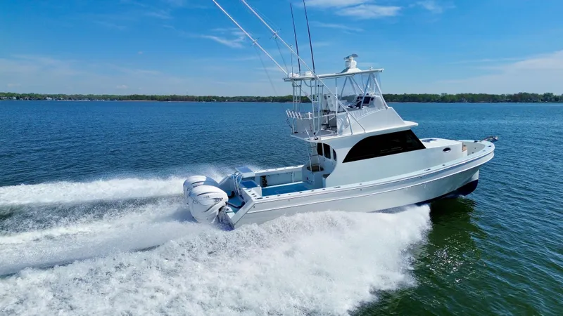 Slide: The Image of 2023 Millennium Marine NuWave 37 cruising on open water, showcasing sleek design and powerful engines. - 2