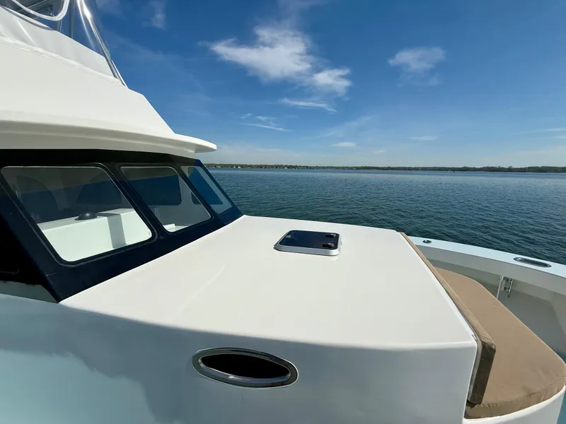 Slide: The Image of 2023 Millennium Marine NuWave 37 yacht on calm water under clear blue sky. - 21