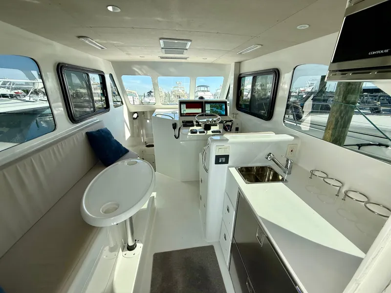 Slide: The Image of Interior of 2023 Millennium Marine NuWave 37 boat with modern helm and seating area. - 24