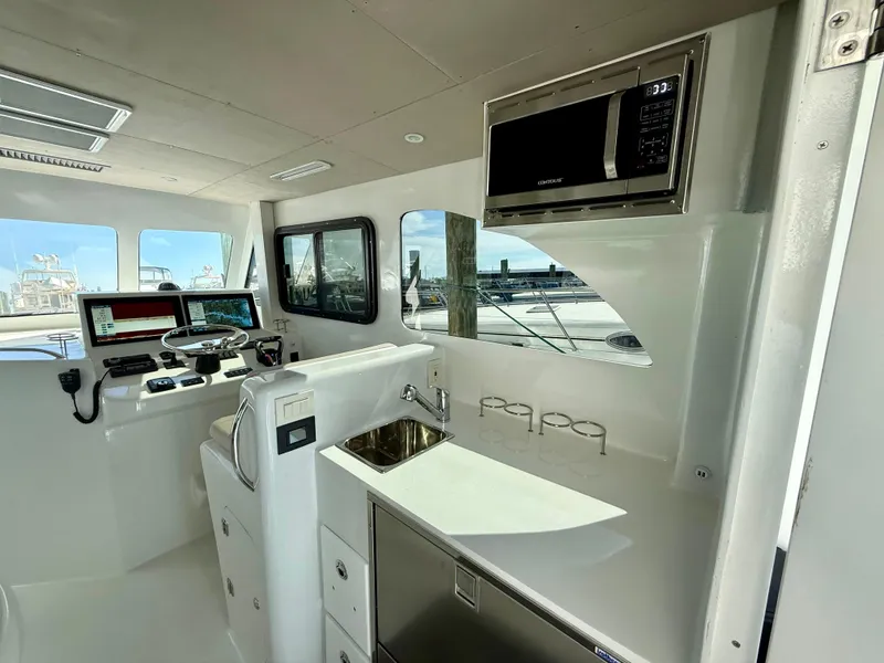 Slide: The Image of Interior of 2023 Millennium Marine NuWave 37 boat with modern helm and kitchenette. - 25