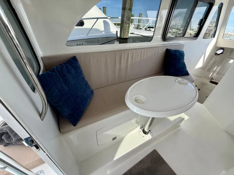 Slide: The Image of 2023 Millennium Marine NuWave 37 interior with cushioned seating and round table. - 26