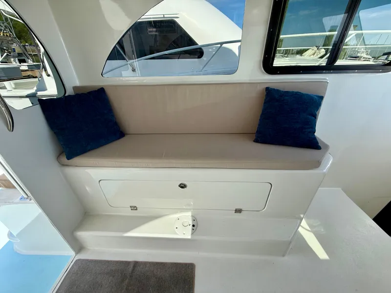 Slide: The Image of 2023 Millennium Marine NuWave 37 interior with cushioned seating and blue pillows. - 27