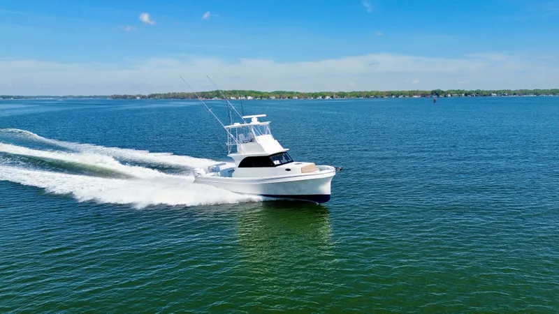 Slide: The Image of 2023 Millennium Marine NuWave 37 cruising on a clear blue lake under a sunny sky. - 3