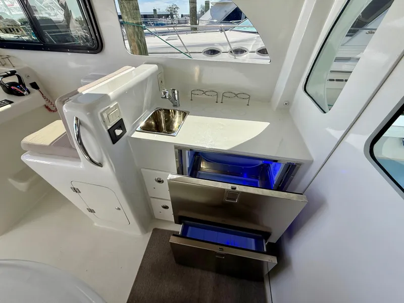 Slide: The Image of Modern kitchenette in 2023 Millennium Marine NuWave 37 boat with sink and storage drawers. - 32