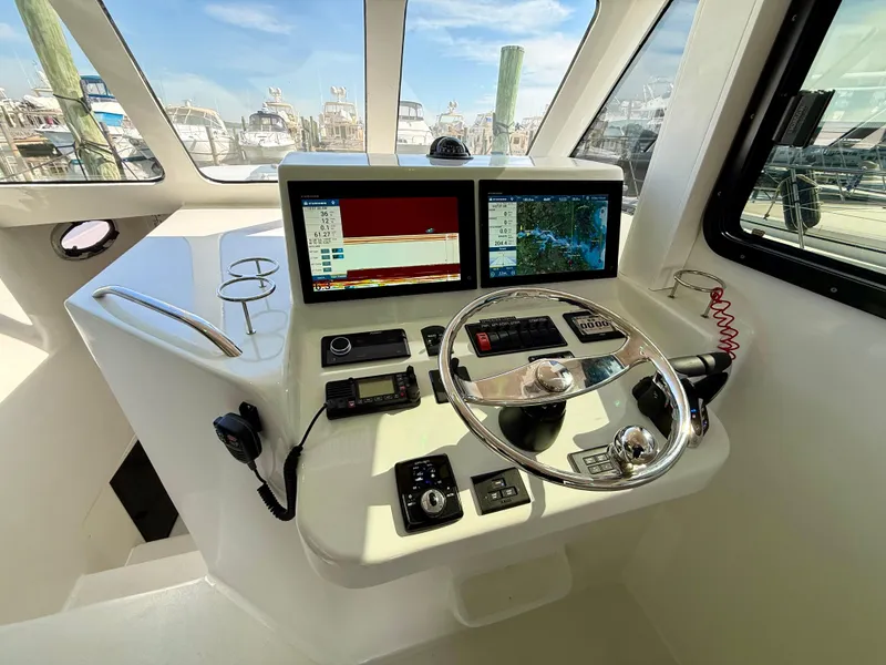Slide: The Image of 2023 Millennium Marine NuWave 37 boat cockpit with dual screens and steering wheel. - 37