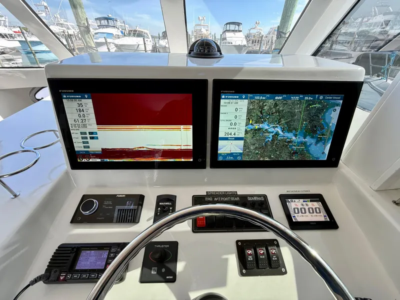Slide: The Image of 2023 Millennium Marine NuWave 37 dashboard with dual navigation screens and control panel. - 38
