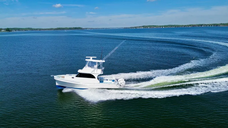 Slide: The Image of 2023 Millennium Marine NuWave 37 cruising on a clear blue lake under a sunny sky. - 4