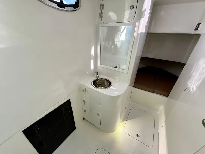 Slide: The Image of 2023 Millennium Marine NuWave 37 interior with sink and storage, featuring sleek white design. - 44
