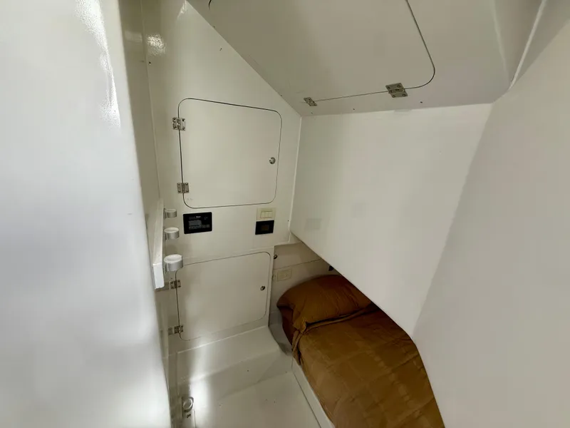 Slide: The Image of 2023 Millennium Marine NuWave 37 cabin interior with compact bed and storage compartments. - 45